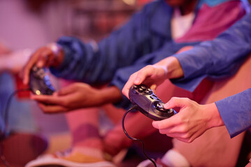 Close up of young people playing retro video game in neon light 80s style, copy space