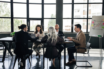 Coworkers Team Sitting At Laptops Having Corporate Conference In Office