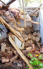 Old abandoned one-story house in disrepair. Collapsed walls.