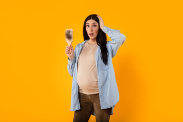 Pregnancy changes. Young expectant mother grappling with hair loss, having problems causes by...