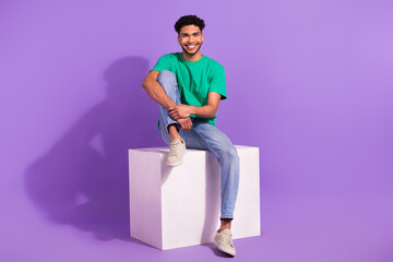 Full body size photo of young cheerful guy sitting platform good mood waiting changing room...
