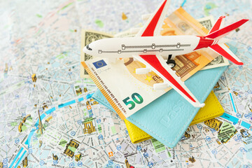 Paris city map composition with euro banknotes, dollars, passports and a toy plane. Travel and vacation concept.