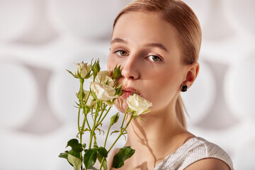 Portrait of a dark blond lady with a gentle makeup. The girl is wearing golden stud earrings made...