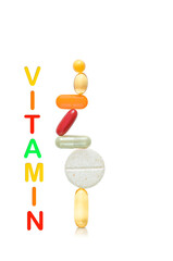 Balance construction of pills and word “vitamin” isolated on white background. Healthy lifestyle concept
