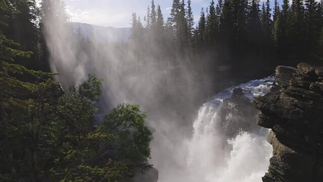 Sunlight forms a spotlight on the Athabasca Falls in slow motion