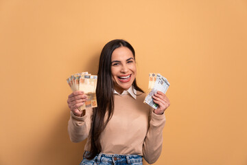 excited young woman with brazil banknotes currency in beige colors. economy, payment, successful...