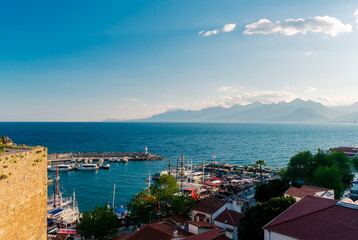 Fototapeta premium Panorama view from a high point on part of the fortress wall and the old port of Kaleichi in the Turkish city of Antalya. Panoramic view of part of the fortress wall and the old port 