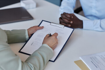 Closeup of unrecognizable senior woman signing contract at job interview, copy space