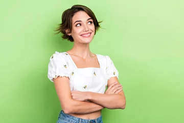 Gordijnen Photo of dreamy adorable woman dressed white top arms crossed looking empty space isolated green color background © deagreez