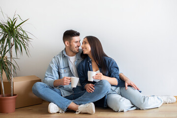 Young Happy Couple Relaxing With Coffee On Moving Day