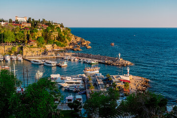 View from a height of the harbor near the old town of Kaleichi in the Turkish city of Antalya. Old port in Antalya with many ships and boats. Popular tourist place in Anatalya. - obrazy, fototapety, plakaty