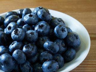 Freshly picked blueberries in a white vintage ceramic bowl. Selective focus, Free text space.