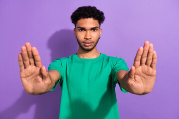 Portrait of serious guy protester activist raise his arms to camera say no stop against war Ukraine...