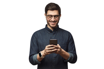 Happy young man in blue denim shirt looking at phone, surfing the web