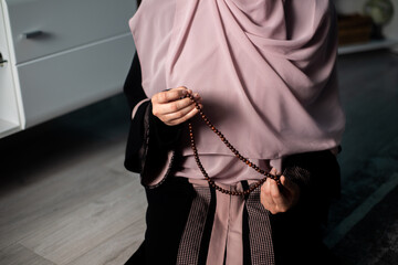 Muslim girly praying in house, reading holy Quran