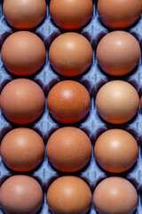 A full frame photograph looking down at eggs in a cardboard egg box