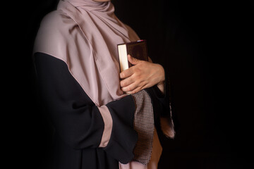 Muslim girly praying in house, reading holy Quran