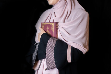 Muslim girly praying in house, reading holy Quran