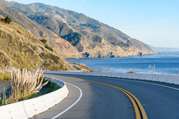 Curve along highway one running along  the rugged coast of California on a sunny autumn day