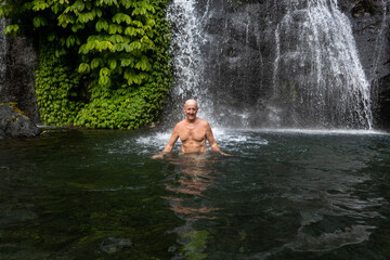 Banyumala waterfall, Bali, Indonesia A man bathes in the waterfall.