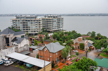 Fototapeta premium Buildings, houses and vegetation in Posadas, Argentina. Nearby town of Encarnacion in Paraguay. Cityscape photography.