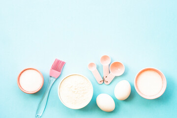 Ingredients for cooking baking on blue. Flour, sugar, eggs and utensils. Top view with space for text.