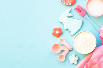 Easter baking, Flour, edds, sugar and gingerbread cookies. Top view on blue.