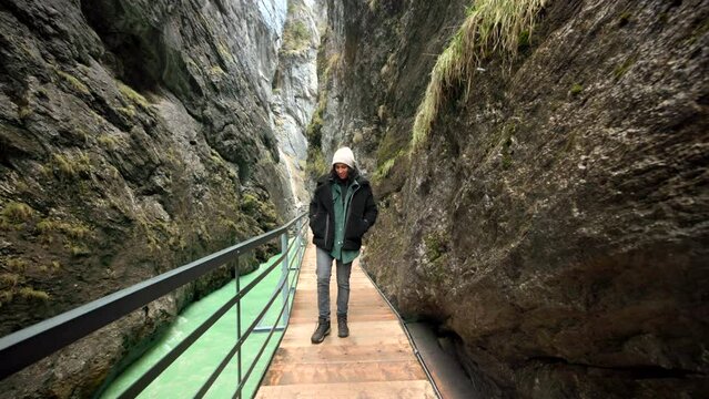 A captivating trek through Aare Gorge with a black-haired lady, immersed in the majestic mountains and enthralled by the mesmerizing power of rocks. High quality 4k footage.