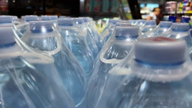Mineral or table water in five-liter bottles in rows in a supermarket or wholesale store. Close-up