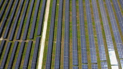 Aerial view of the rows of solar panels, large solar power plant. Production of a large amount of clean electricity from renewable sources. The concept of zero emissions and environmental protection