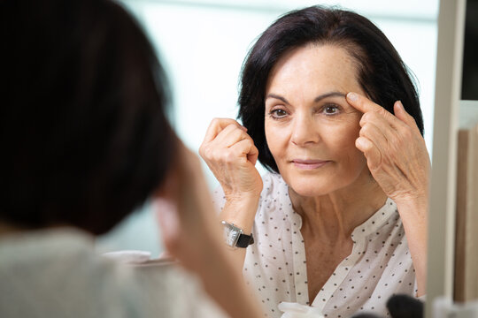 woman applying eyeshadow on the mirrow