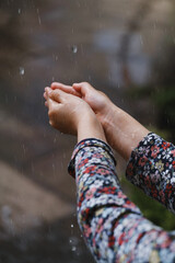 kids hands catching raindrops, weather concept. Closeup of rain falling in hands