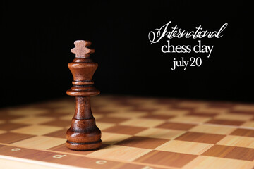 Board with king on dark background. International Chess Day