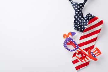 USA Independence Day theme with top-view arrangement of party paraphernalia: party eyeglasses, and necktie in national flag colors on white background, offering space for text or advertising