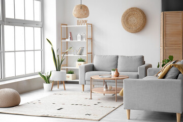 Interior of light living room with grey sofas and wooden coffee table