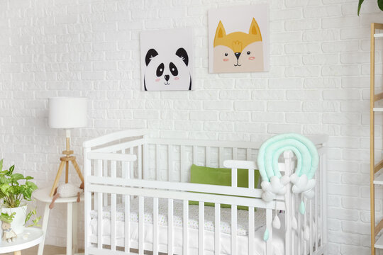 Interior of light bedroom with baby crib