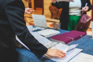 Process of checking in on a conference congress forum event, registration desk table, visitors and attendees receiving a name badge and entrance wristband bracelet and register electronic ticket