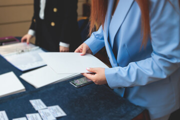 Process of checking in on a conference congress forum event, registration desk table, visitors and attendees receiving a name badge and entrance wristband bracelet and register electronic ticket