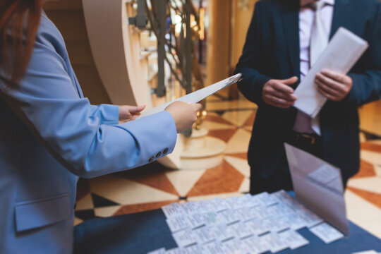 Process of checking in on a conference congress forum event, registration desk table, visitors and attendees receiving a name badge and entrance wristband bracelet and register electronic ticket