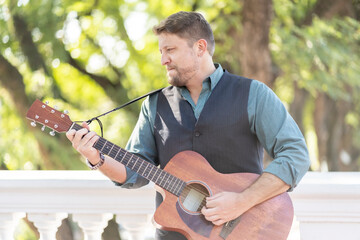 Musician man playing guitar and singing in the street