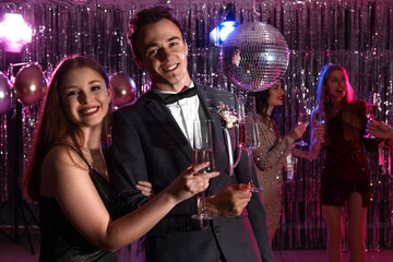 Young couple drinking champagne on prom night