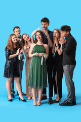 Young people crowning prom queen on blue background © Pixel-Shot