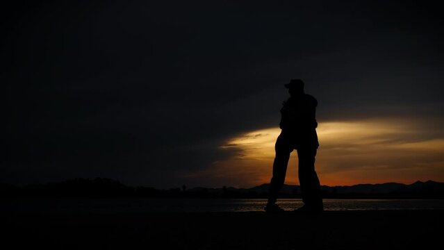 Teen with dad silhouette on beach. A view of young girl with father silhouette embracing and pass free time on the beach during dusk time.