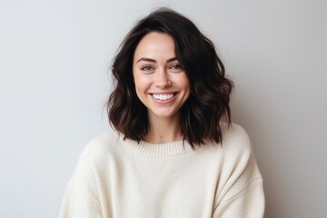 Obraz premium Portrait of a beautiful young woman with long brown hair in a white sweater