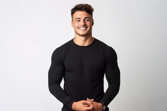 Portrait of a handsome young man in black t-shirt standing isolated over white background