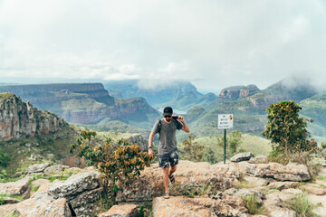 Man on a cliff with a the view from the top of the Blyde river canyon in South Africa.