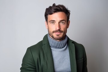 Obraz premium Portrait of a handsome bearded man wearing green sweater and gray scarf