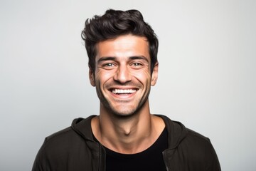 Obraz premium Portrait of a happy young man looking at camera over gray background