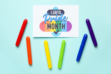 Card with text LGBTQ PRIDE MONTH and colorful pens on blue background