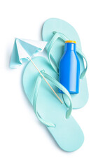 Bottle of sunscreen cream with mini umbrella and flip flops isolated on white background